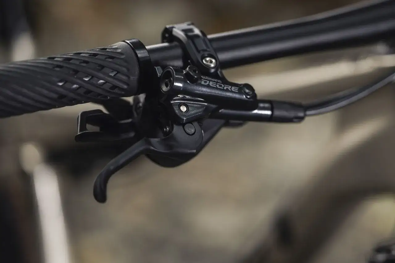 Manetka Shimano Deore, część mechanizmu zmiany biegów, pokazuje różne rodzaje przerzutek rowerowych w akcji.