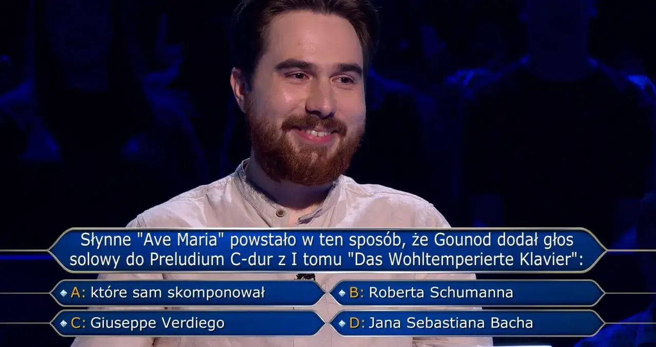 Uśmiechnięty uczestnik w programie Milionerzy zastanawia się, gdzie jest błąd w pytaniu o "Ave Maria" Gounoda.
