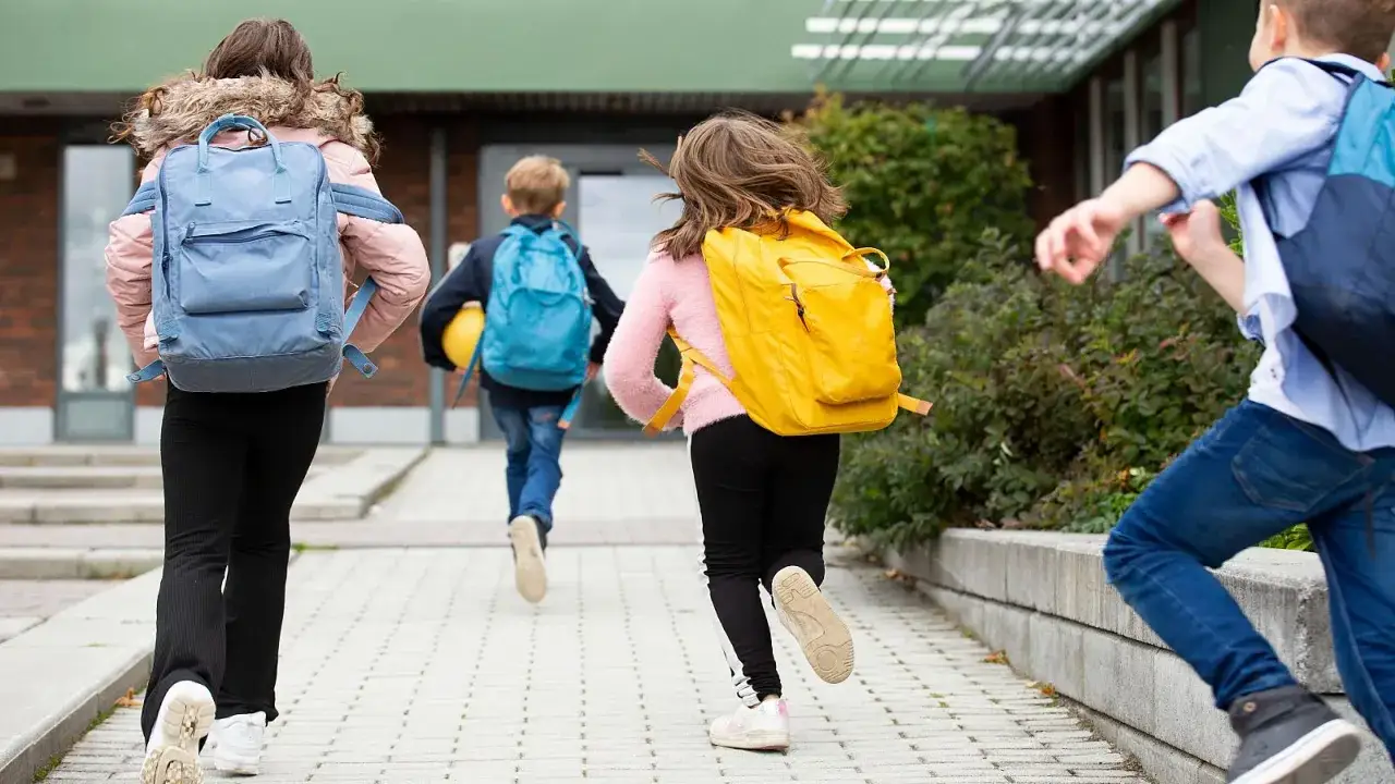 Niños corren con mochilas, ¡parece que ya empiezan las vacaciones de invierno!