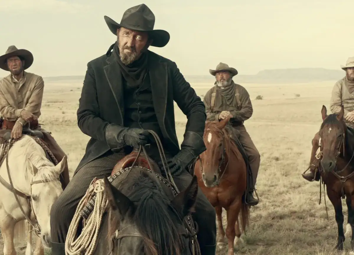 Ballada o Busterze Scruggsie obsada: czterech mężczyzn w kapeluszach i strojach kowbojskich na koniach, na tle pustkowia.