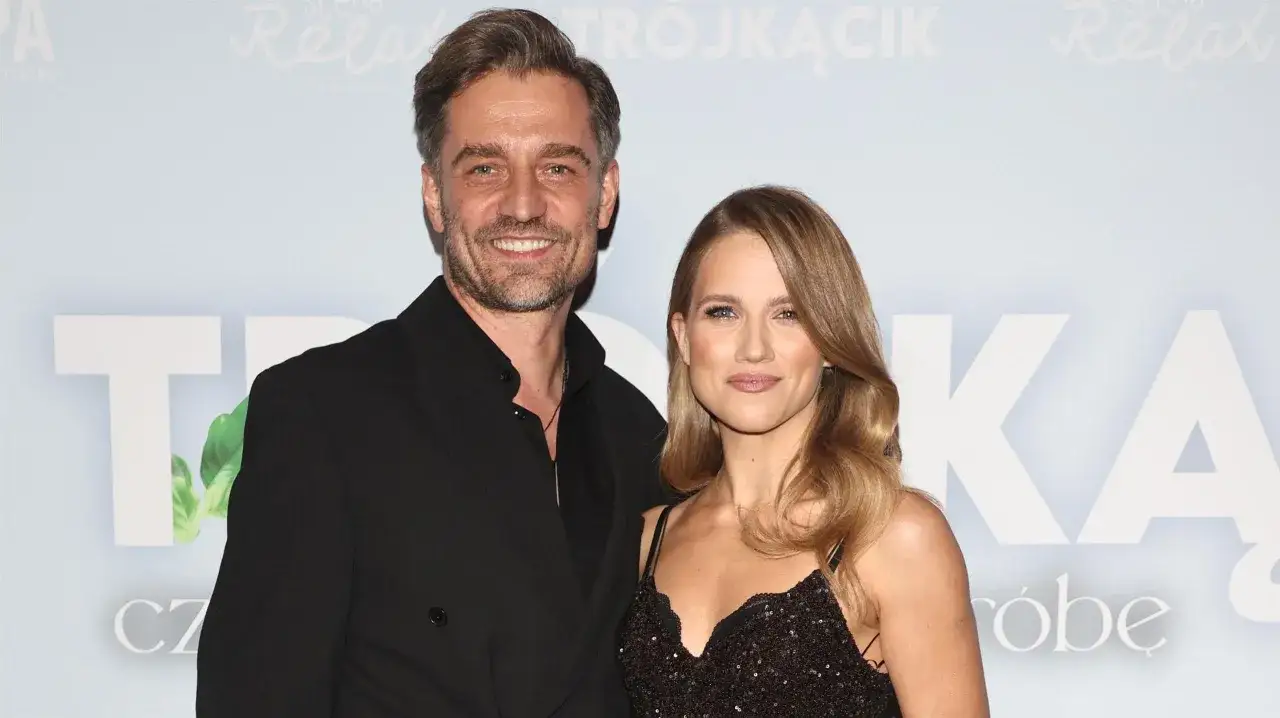 Uśmiechnięty mężczyzna i Daria Zawratyńska w błyszczącej sukience pozują do zdjęcia na tle napisu "SCENA RELAX".