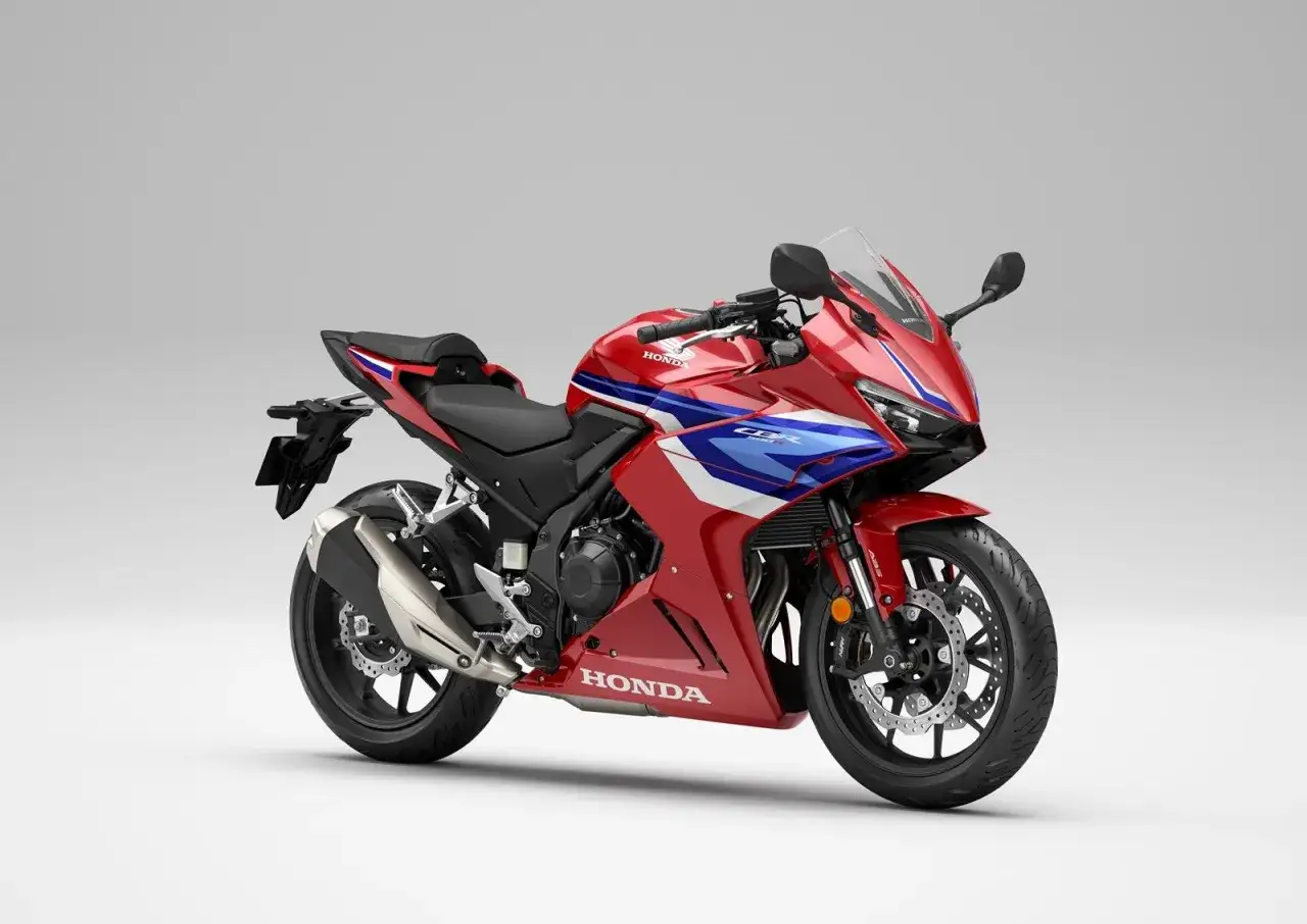 Sportowy motocykl Honda seria CBR w czerwono-niebiesko-białych barwach, gotowy do dynamicznej jazdy.