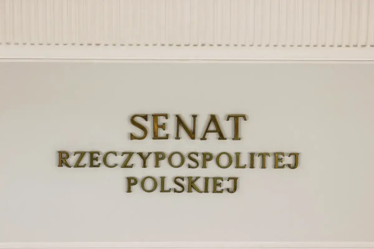 Napis "SENAT RZECZYPOSPOLITEJ POLSKIEJ" złotymi literami na jasnej ścianie.