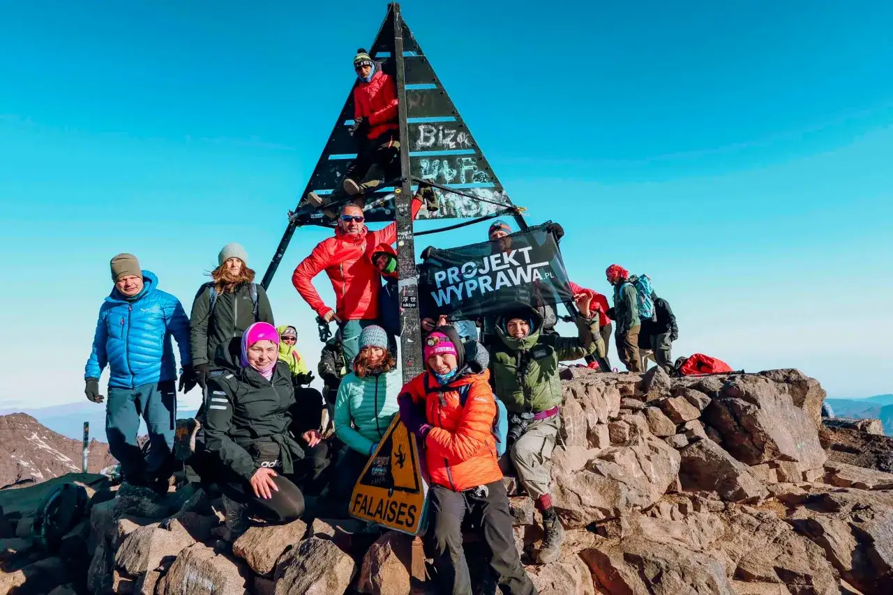 Grupa zdobywców na szczycie Jabal Toubkal, z flagą "PROJEKT WYPRAWA.PL".