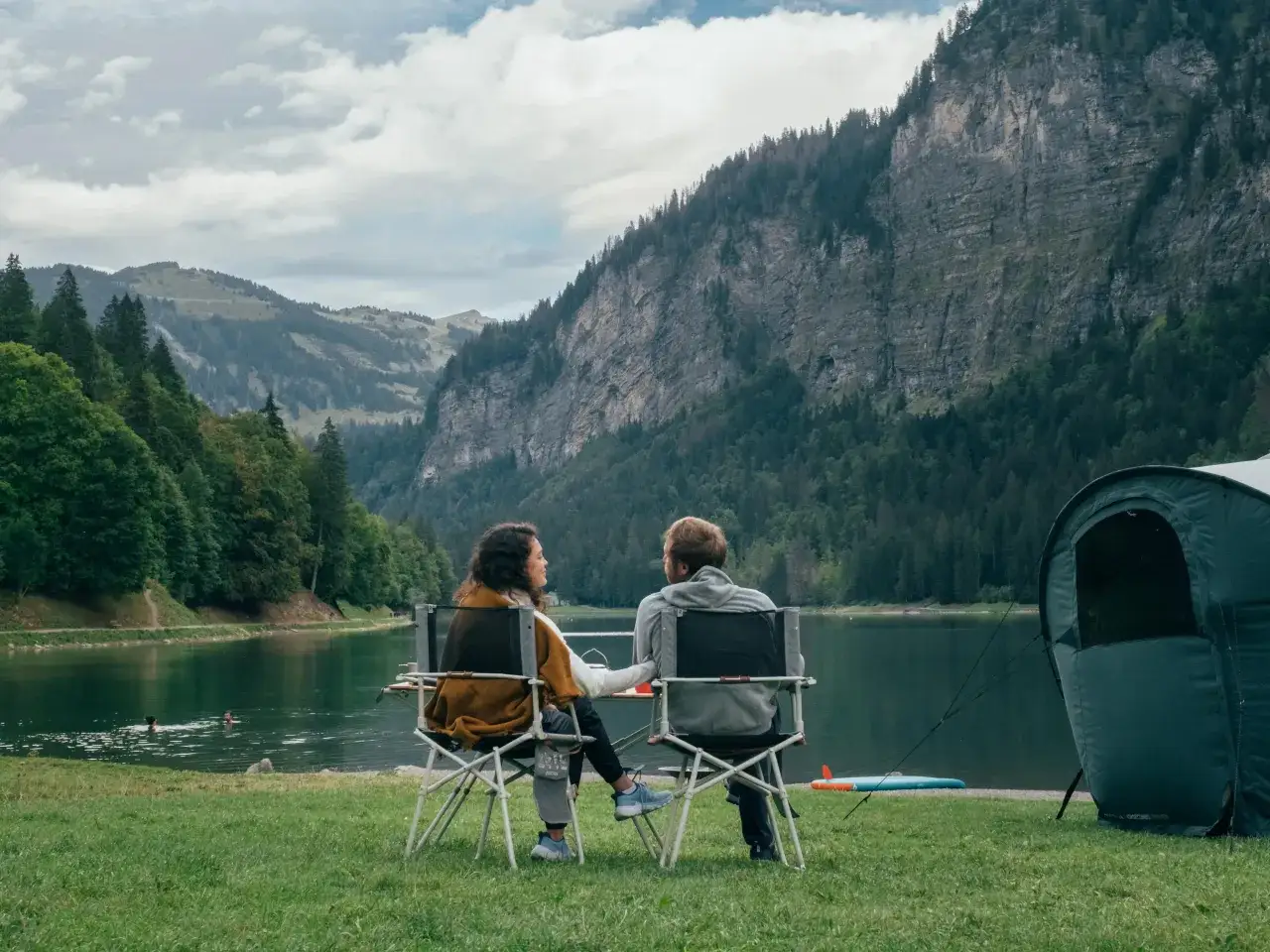 Para odpoczywa nad jeziorem, ciesząc się widokiem gór. To idealne miejsce na włochy spanie na dziko.