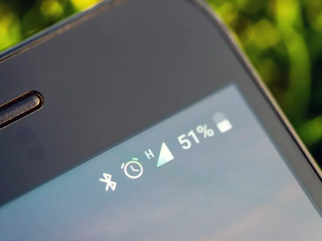 Zbliżenie na ekran smartfona z ikoną Bluetooth, zegarem i wskaźnikiem baterii 51%.