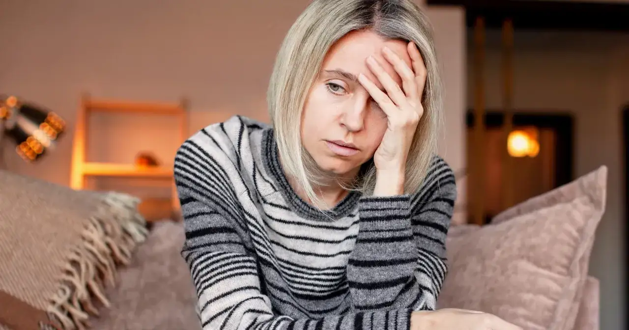 Kobieta z bólem głowy, szukająca sposobu, jak szybko pozbyć się bólu głowy.