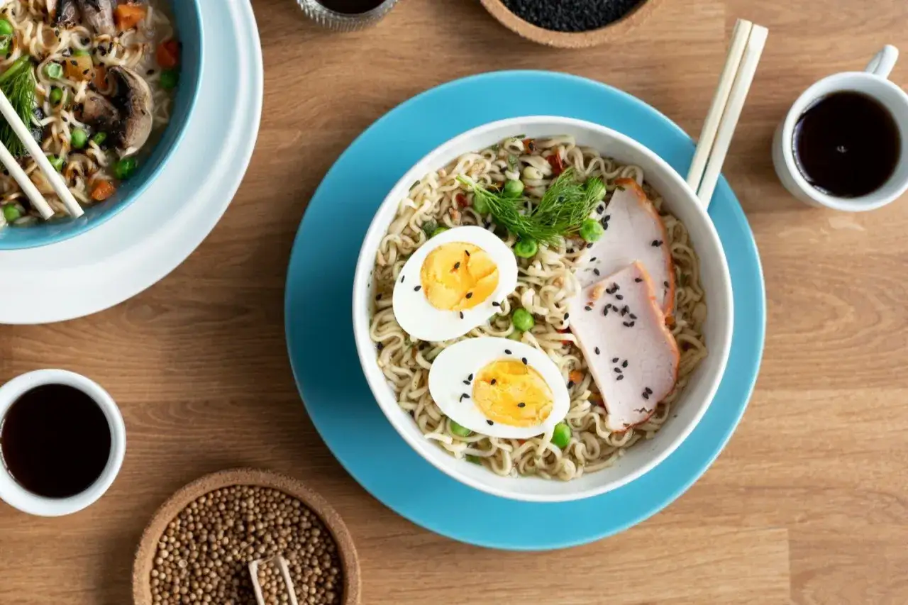 Pyszny tantanmen ramen z jajkiem, plastrami mięsa i zielonym groszkiem. Idealny na szybki, sycący posiłek.