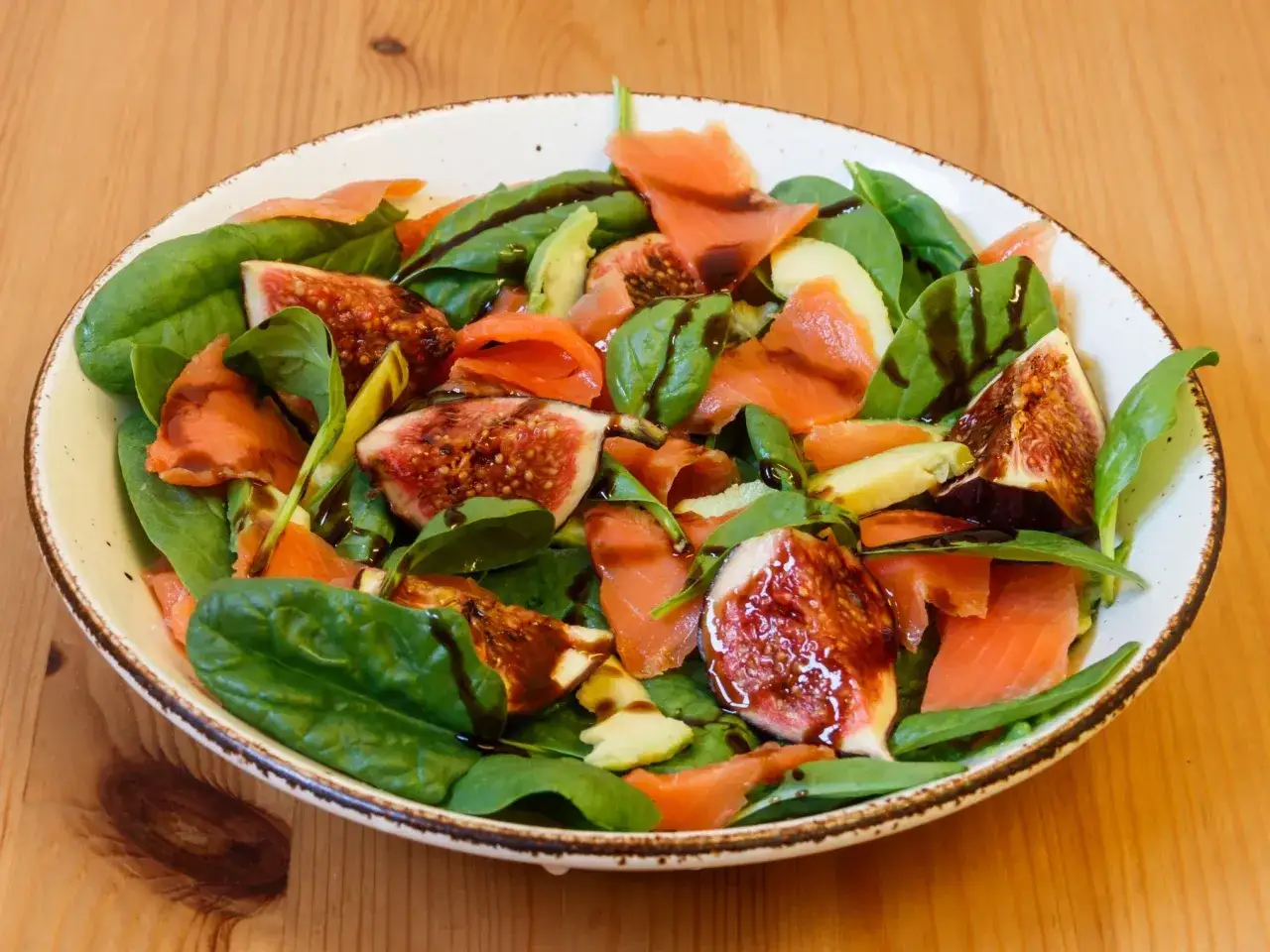 Sałatka z wędzonym łososiem, figami i awokado na liściach szpinaku. Idealna inspiracja, co zrobić z rukoli na obiad, gdy chcesz czegoś lekkiego i pysznego.
