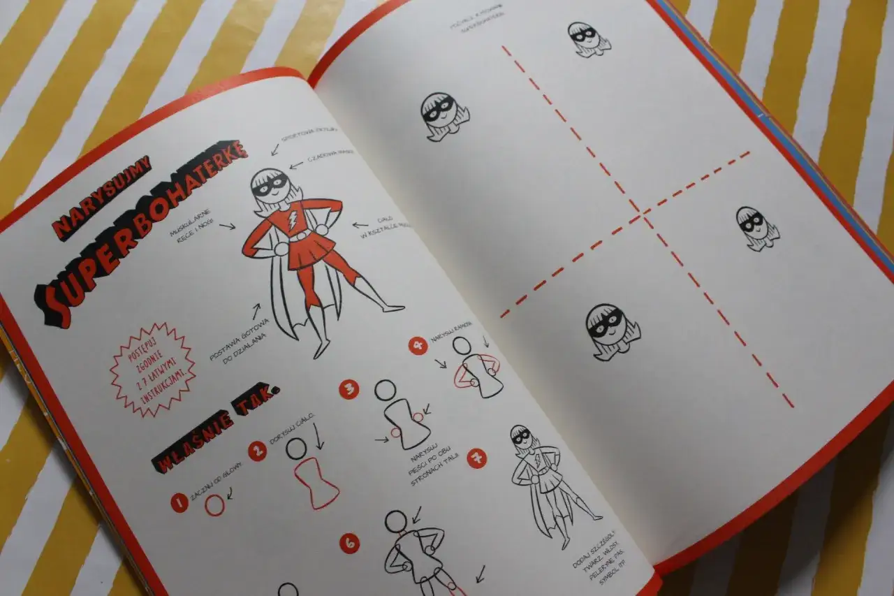 Otwarta książka z instrukcją rysowania superbohaterki krok po kroku.