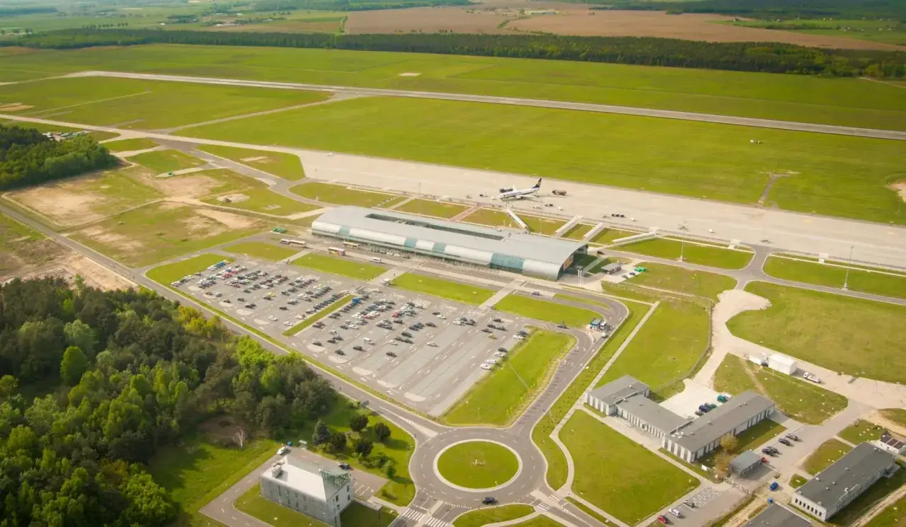 Widok z lotu ptaka na lotnisko z terminalem, parkingiem i pasami startowymi. Ile jest pasów startowych w Warszawie? Na tym zdjęciu widać dwa pasy.