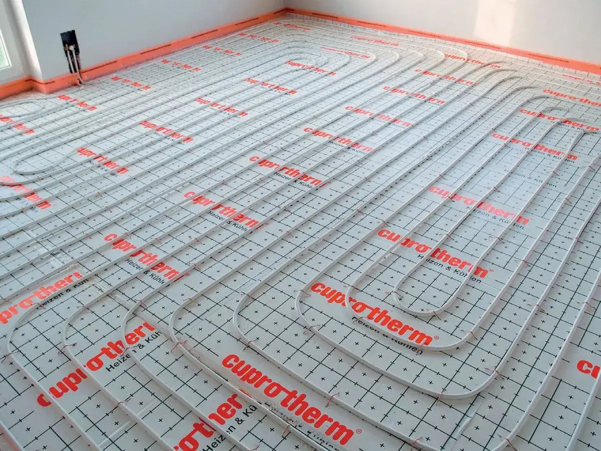 System ogrzewania podłogowego Cuprotherm w trakcie montażu. Wybór między ogrzewaniem podłogowym a grzejnikami to ważna decyzja.