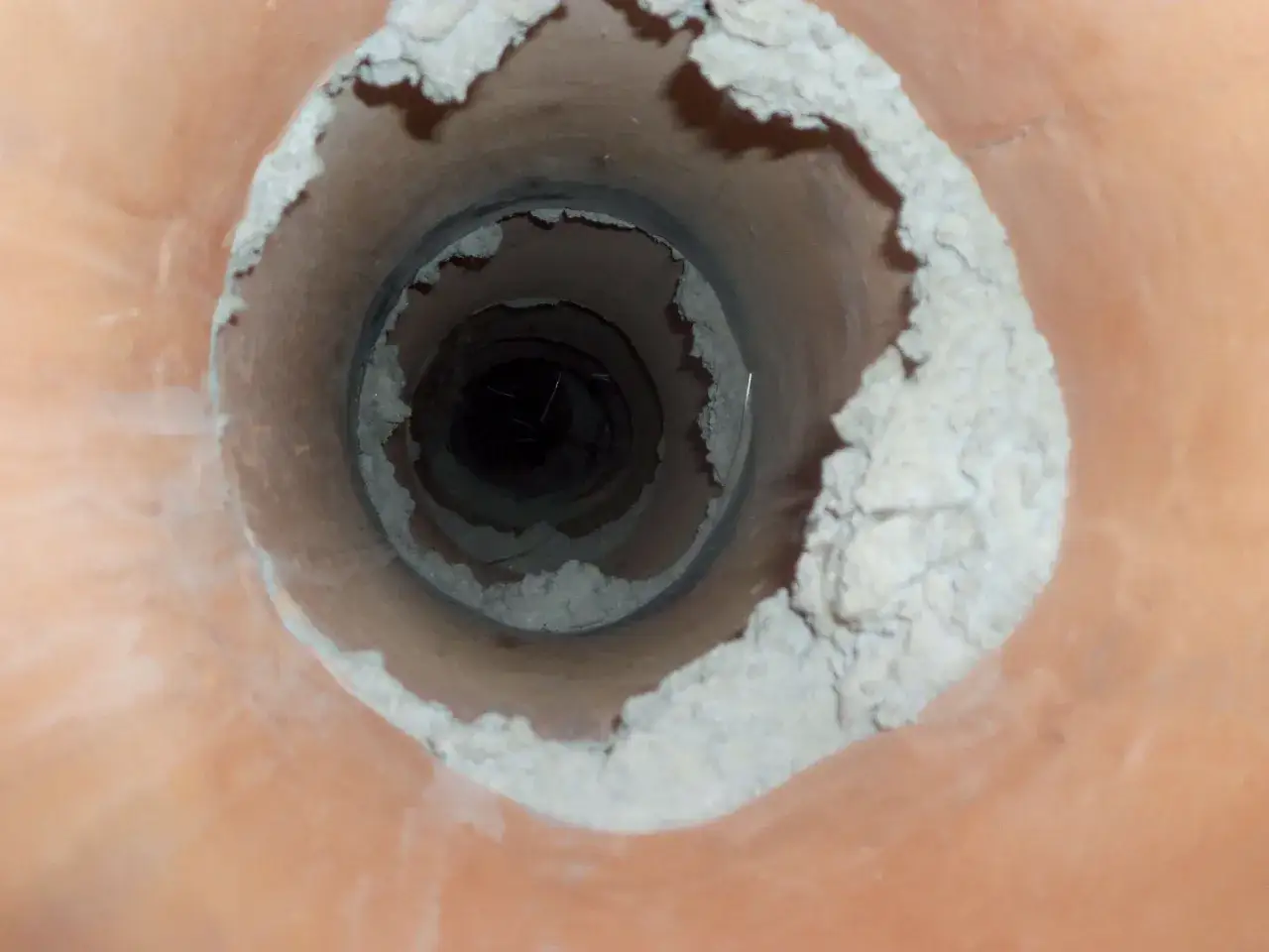 Widok wnętrza komina z osadem. Zastanawiasz się, ile kosztuje frezowanie komina?