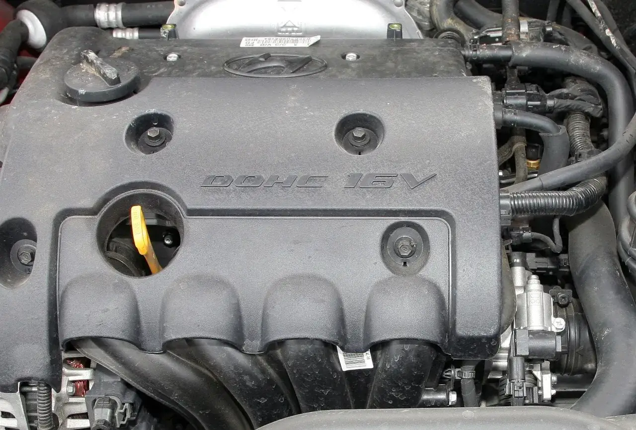 Silnik samochodowy z napisem DOHC 16V. DOHC to skrót od "Double Overhead Camshaft", co oznacza podwójny wałek rozrządu umieszczony nad głowicą.