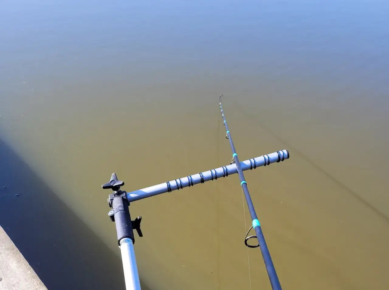 Wędka trzyczęściowa na stojaku nad wodą. Proste wskazówki, jak składać wędkę trzyczęściową, by była gotowa do łowienia.