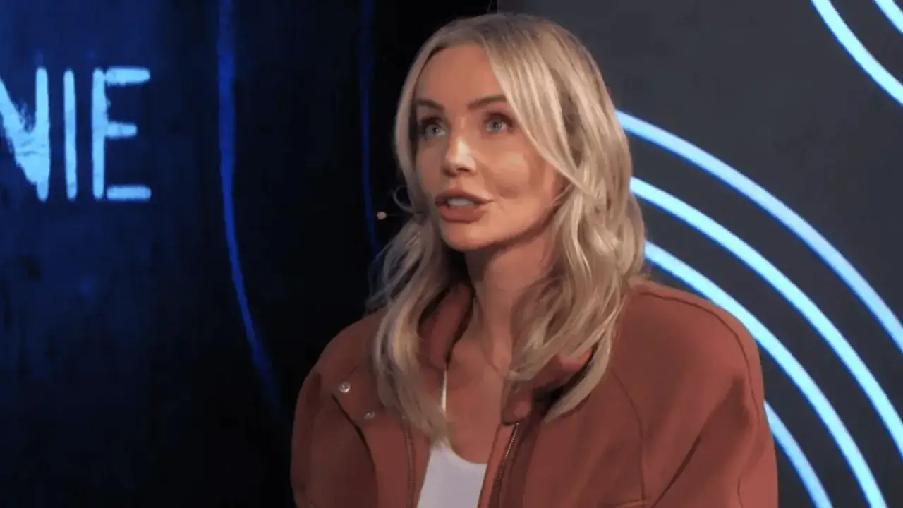 Blondynka w rudym swetrze, jakby kelnerka staraka przerywa milczenie, mówi coś do mikrofonu.