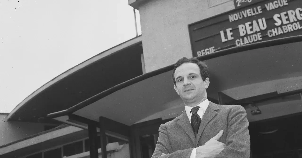 Jean Pierre Léaud w garniturze, z rękami skrzyżowanymi na piersi, przed budynkiem z napisem "Le Beau Serge".