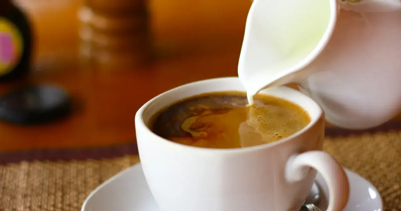 Mleko wlewane do kawy. Zastanawiasz się, ile kalorii ma kawa z mlekiem? To zależy od ilości i rodzaju mleka.