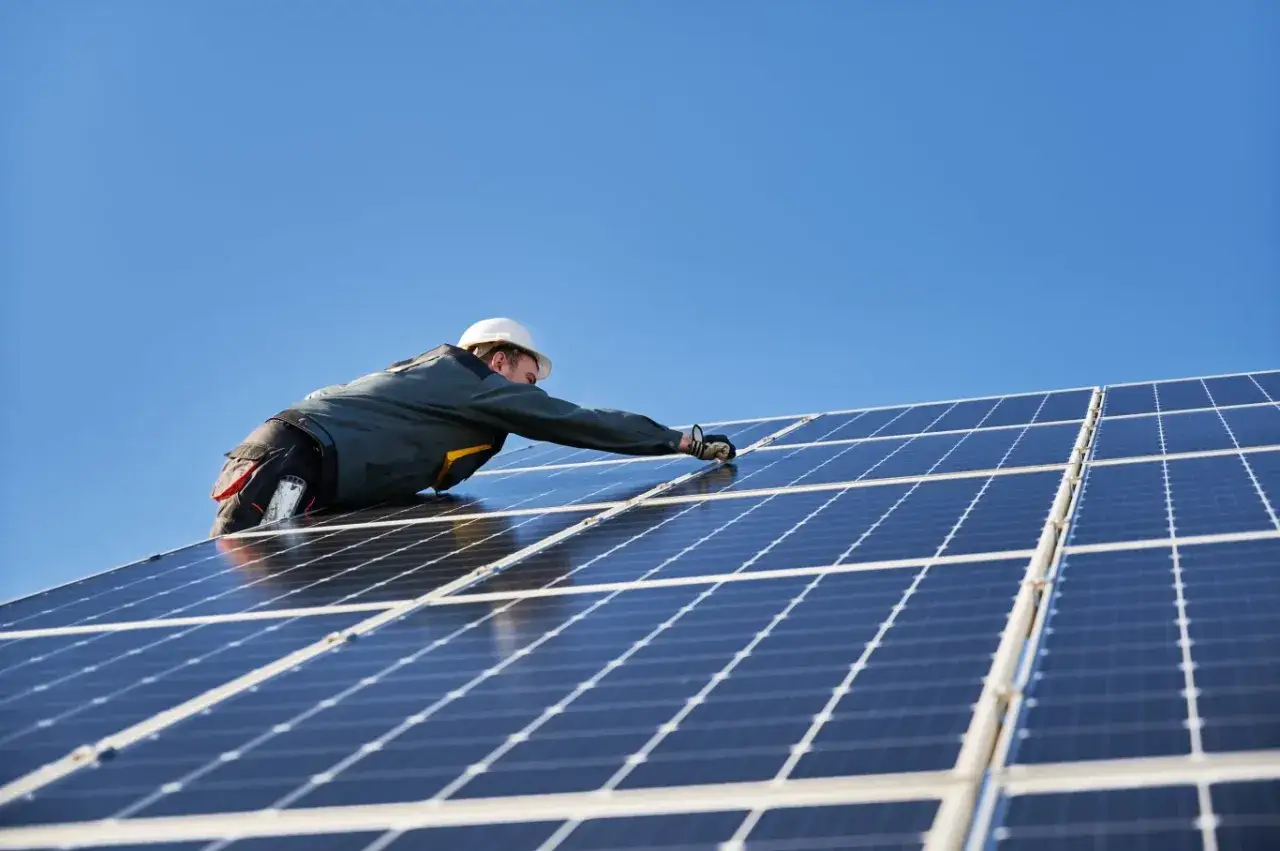 Instalator montuje panele fotowoltaiczne. Nowa ustawa o OZE jakie czekają nas zmiany w energetyce odnawialnej.