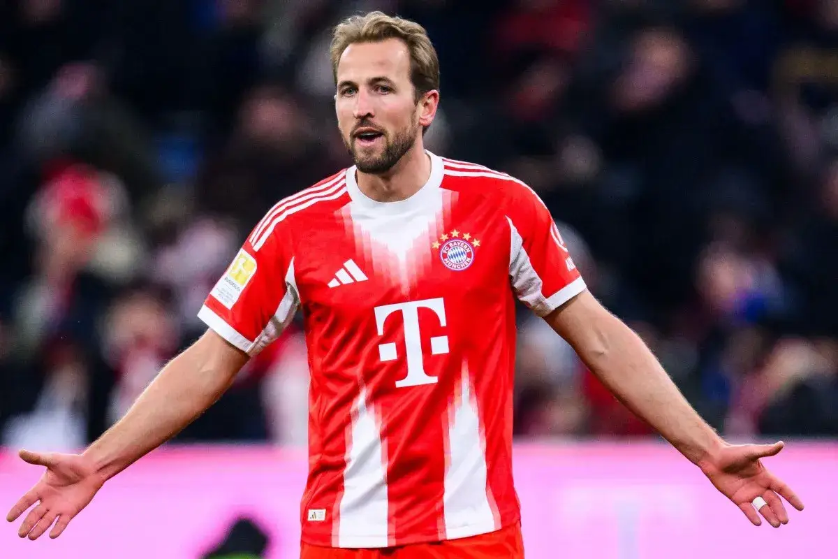 Piłkarz Harry Kane w czerwonej koszulce Bayernu Monachium, zastanawia się, ile zarabia.