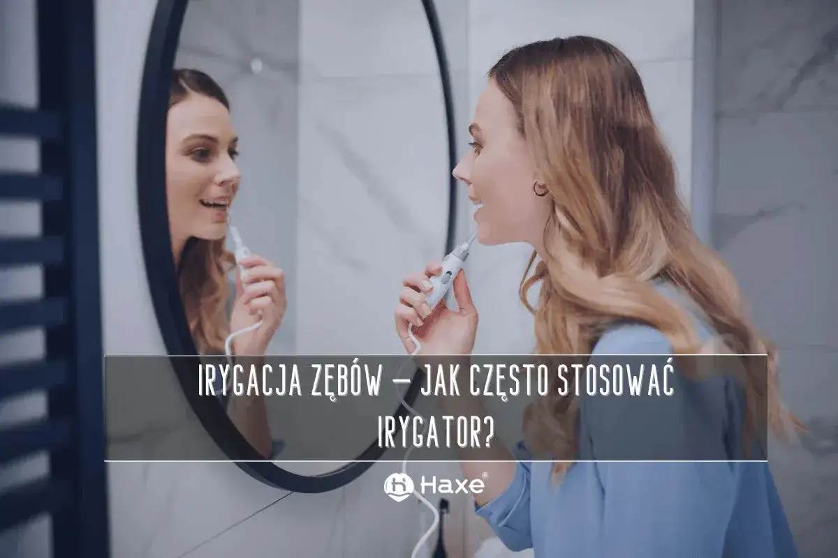 Kobieta używa irygatora do zębów przed lustrem. Dowiedz się, jak często stosować irygator dla zdrowego uśmiechu.