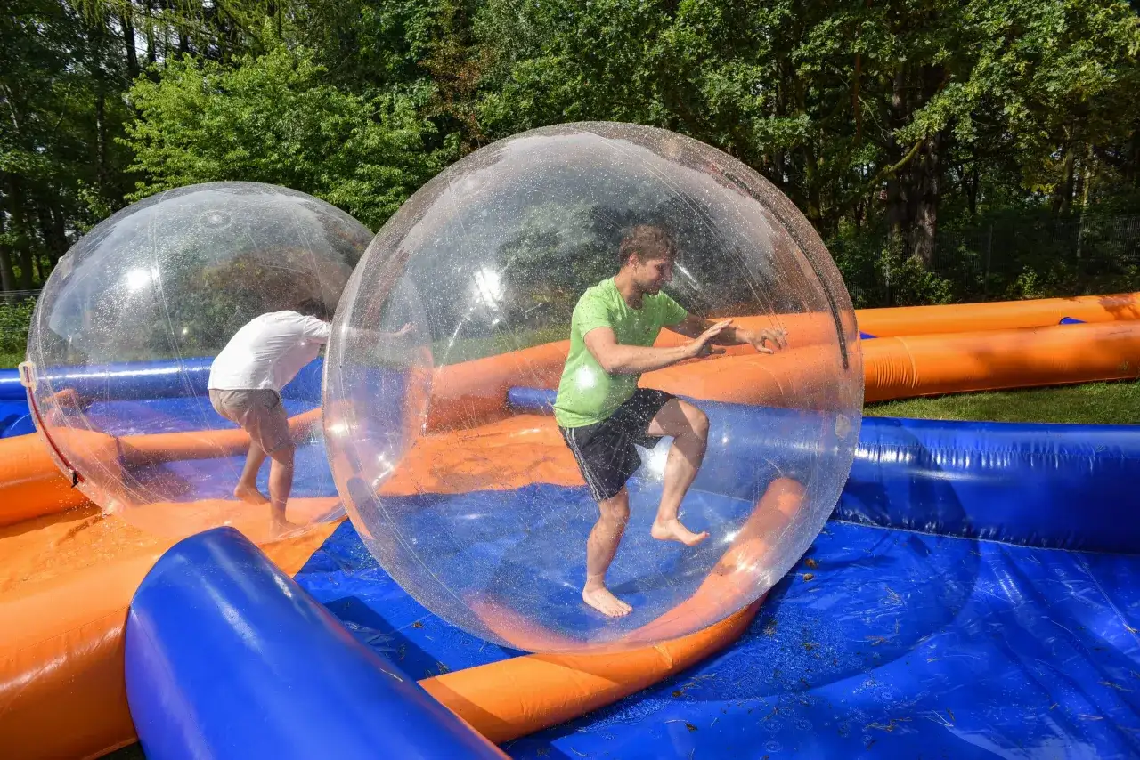 Świetne pomysły na team building: ludzie w dmuchanych kulach na wodzie, śmiech i zabawa gwarantowane!