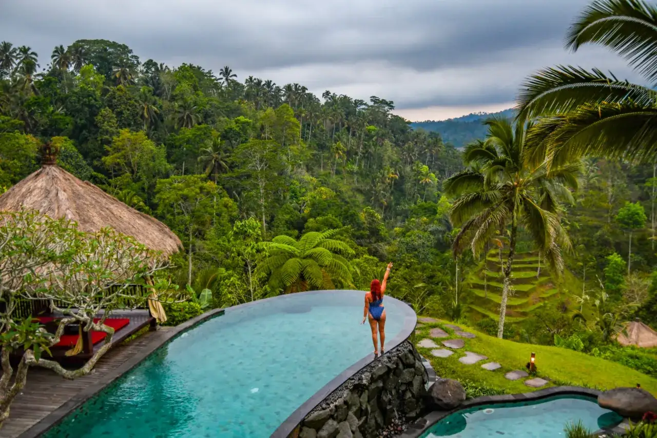 Kobieta w basenie z widokiem na tropikalną dżunglę i tarasowe pola ryżowe. Bali czy warto? Odpowiedź brzmi: tak!