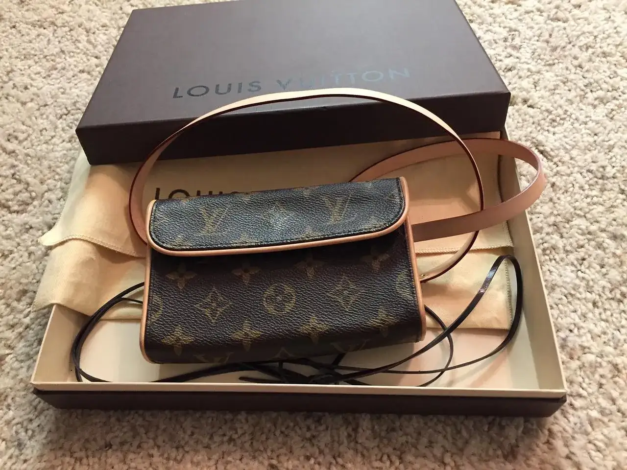 Mała torebka Louis Vuitton w brązowym monogramie, w pudełku z logo marki.