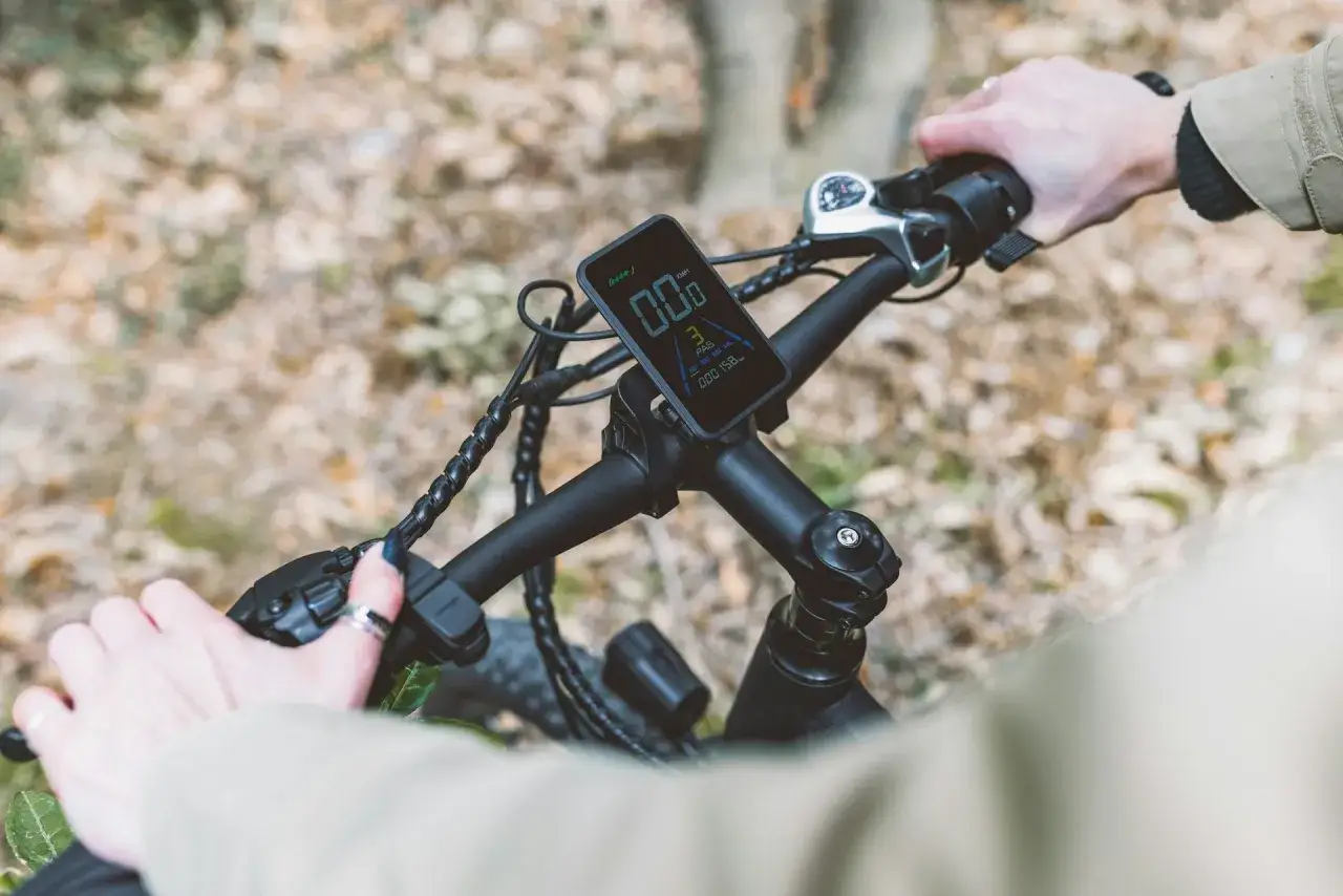 Ręce na kierownicy roweru elektrycznego, wyświetlacz pokazuje prędkość. Ant+ co to za technologia?