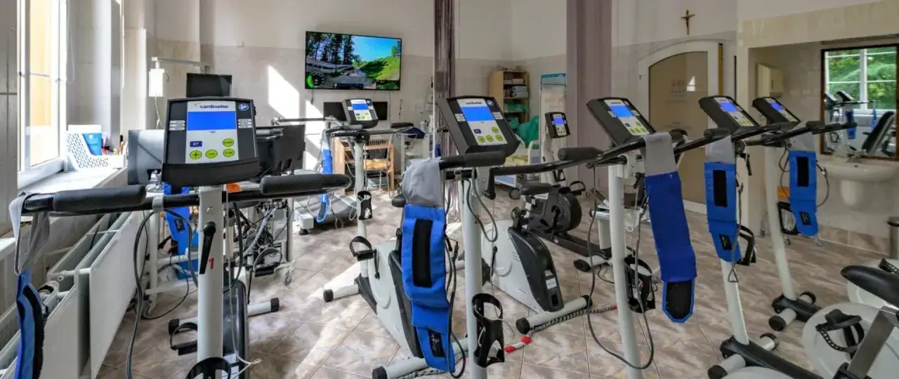 Sala rehabilitacji kardiologicznej z bieżniami i rowerami stacjonarnymi. Tu znajdziesz najlepszą rehabilitację kardiologiczną.