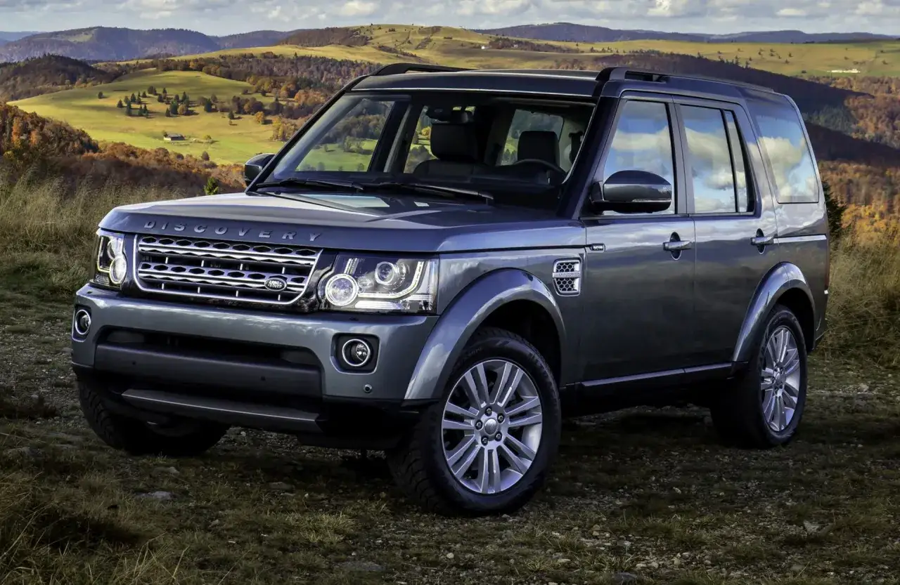 Szary Land Rover Discovery 3 na tle jesiennych wzgórz. Gotowy na każdą przygodę.