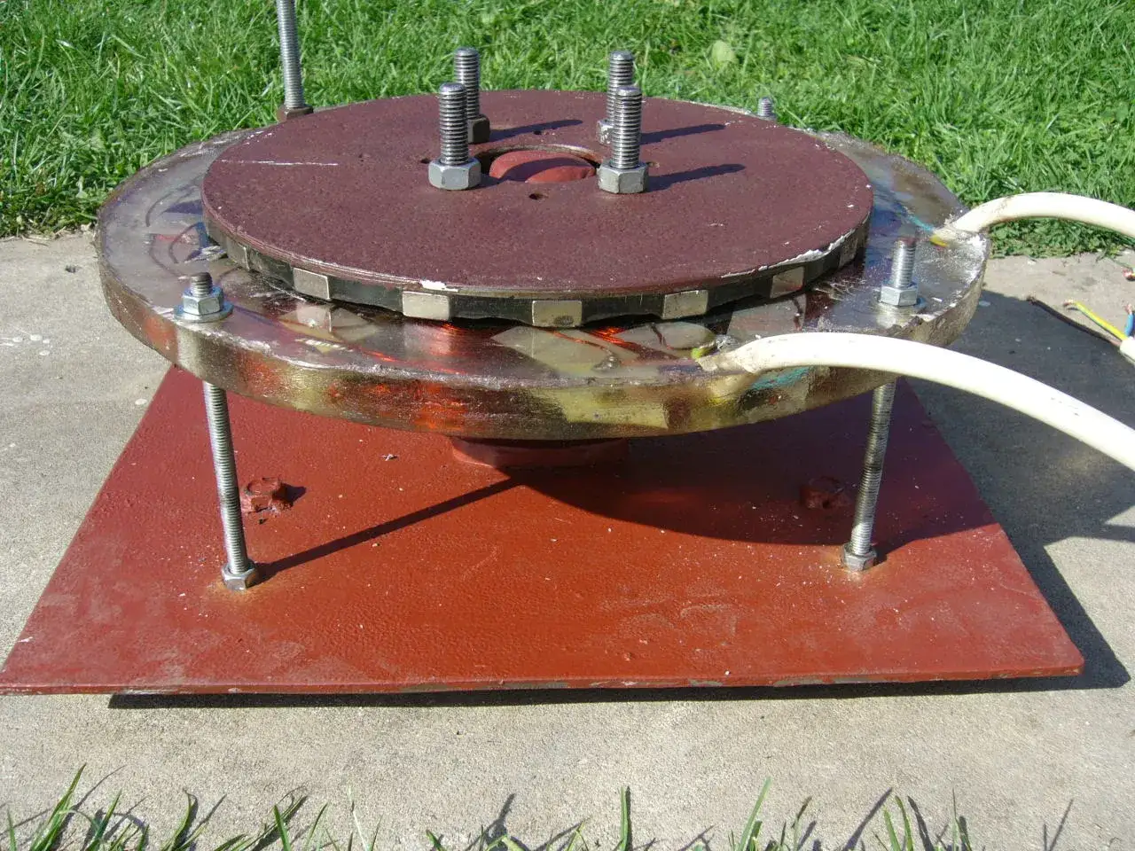 Domowa turbina wodna z magnesami i przewodami, zamontowana na podstawie.