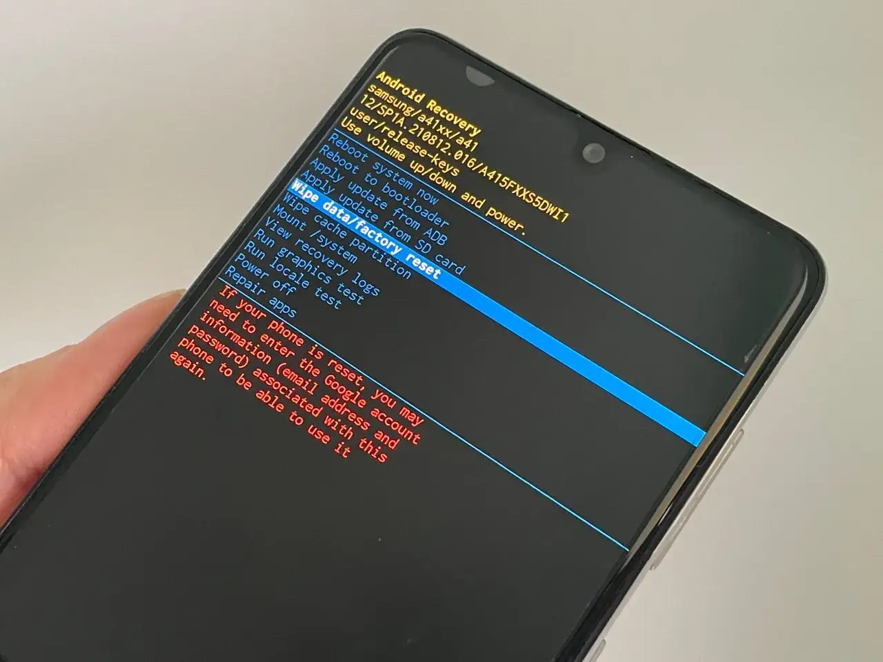 Ekran telefonu Samsung z menu Android Recovery, opcja "Wipe data/factory reset" podświetlona na niebiesko.