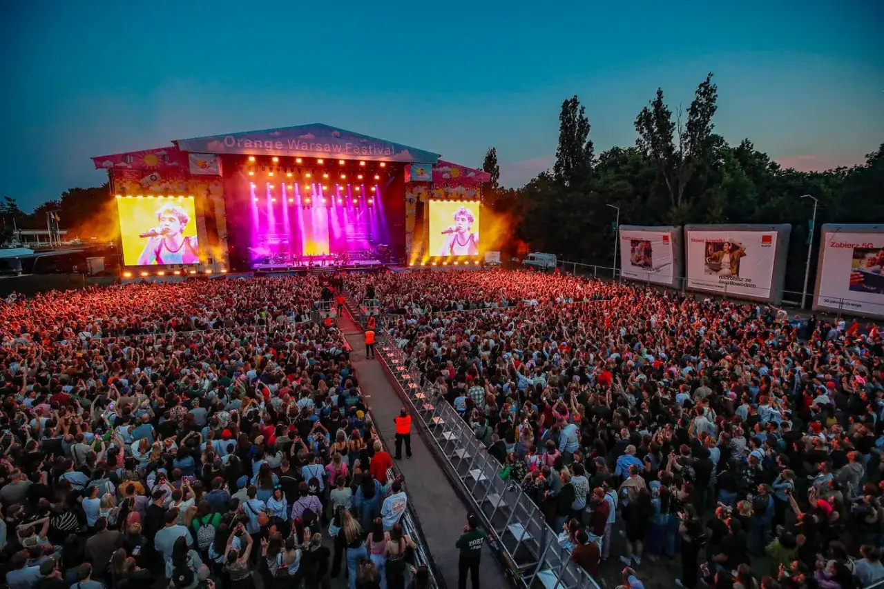 Koncert na Orange Warsaw Festival z tłumem widzów i artystą na telebimie.
