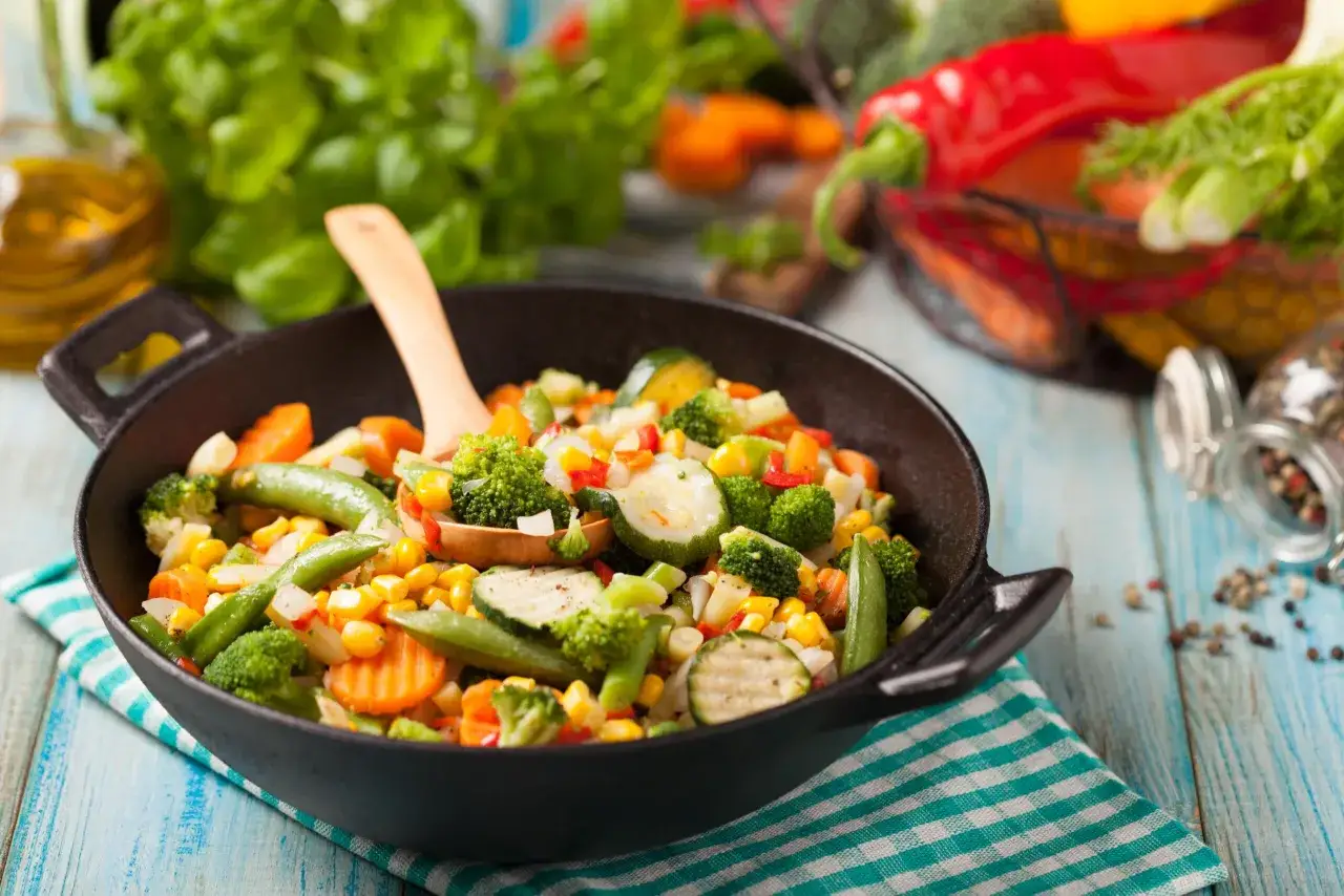 Kolorowa mieszanka warzyw na patelni, idealna odpowiedź na pytanie co zjeść na obiad fit. Brokuły, marchewka, cukinia, groszek i kukurydza.