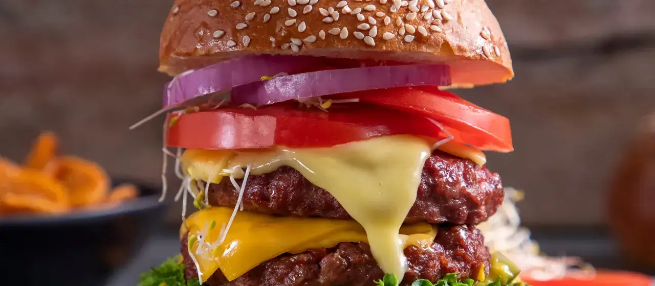 Burger domowy kontra cheeseburger z sieciówki. Podwójna wołowina, ser, pomidor, cebula i kiełki w domowym wydaniu.