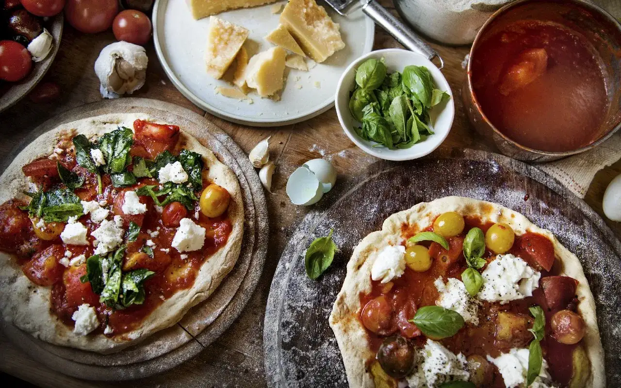 Dwie pizze margherita z pomidorami, mozzarellą i bazylią. Zastanawiasz się, ile kalorii ma pizza margherita?