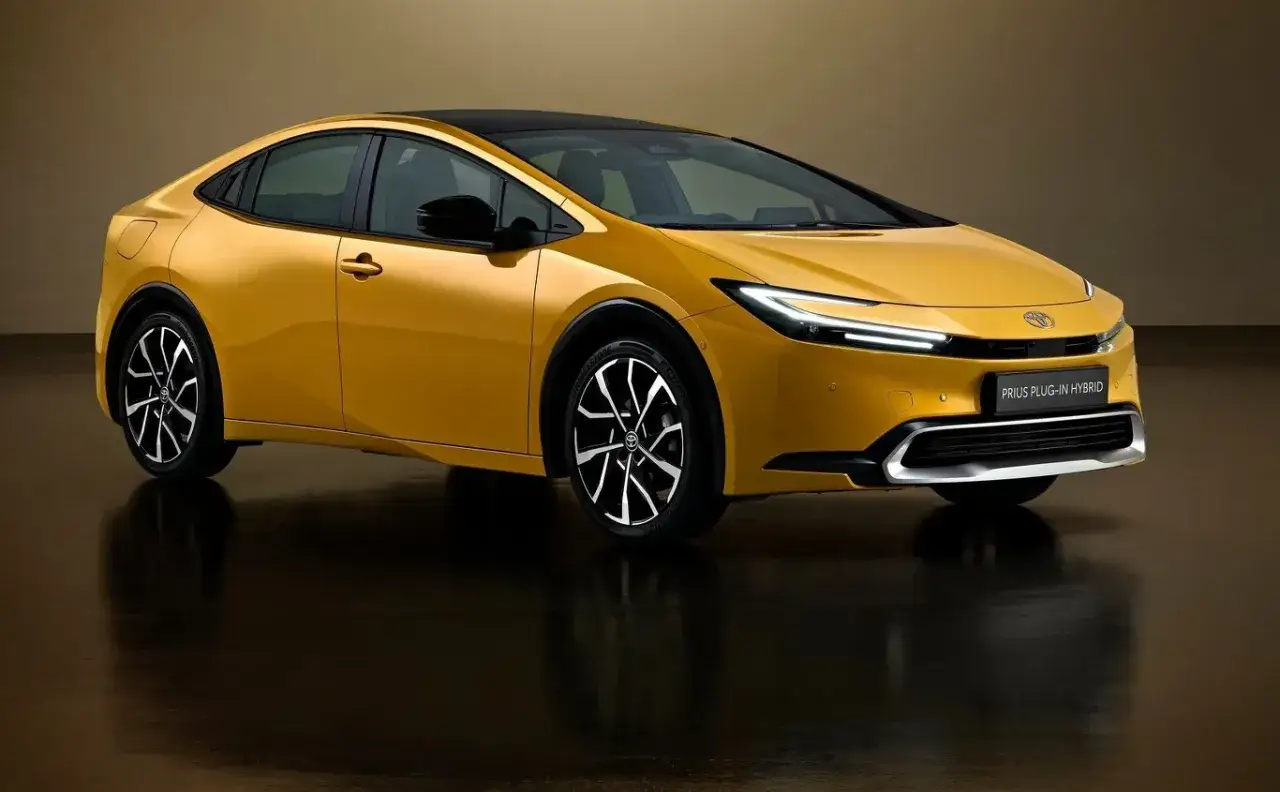 Nowy Toyota Prius V generacji w kolorze złotym, z czarnym dachem, na tle studyjnym.