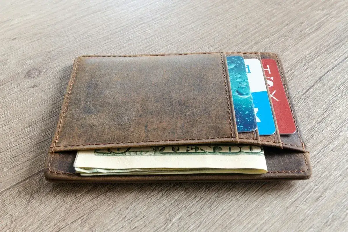Brązowy, skórzany portfel z kartami i banknotami. Dowiedz się, jak wyczyścić skórzany portfel, by wyglądał jak nowy.