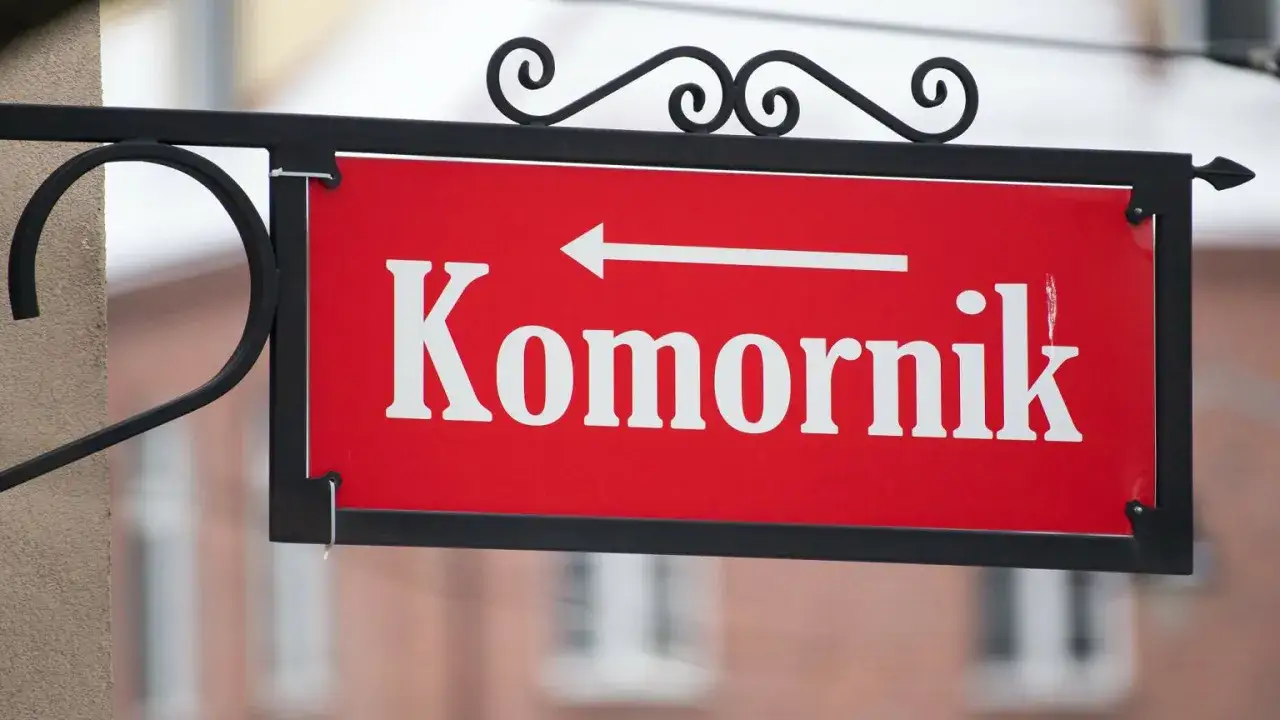 Tabliczka "Komornik" z białą strzałką w lewo. Zastanawiasz się, ile komornik może zabrać z emerytury?