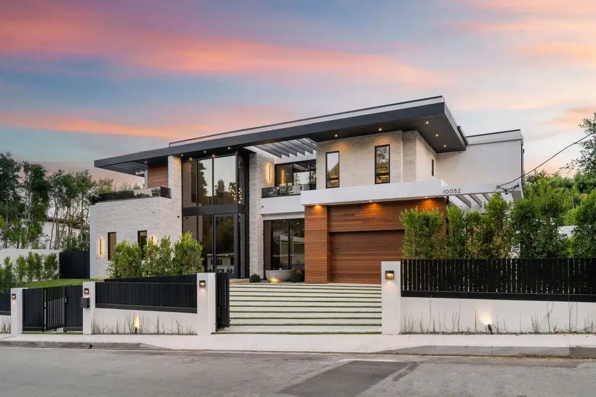 Nowoczesny, luksusowy dom z białego kamienia i drewna z dużymi oknami i ogrodem.