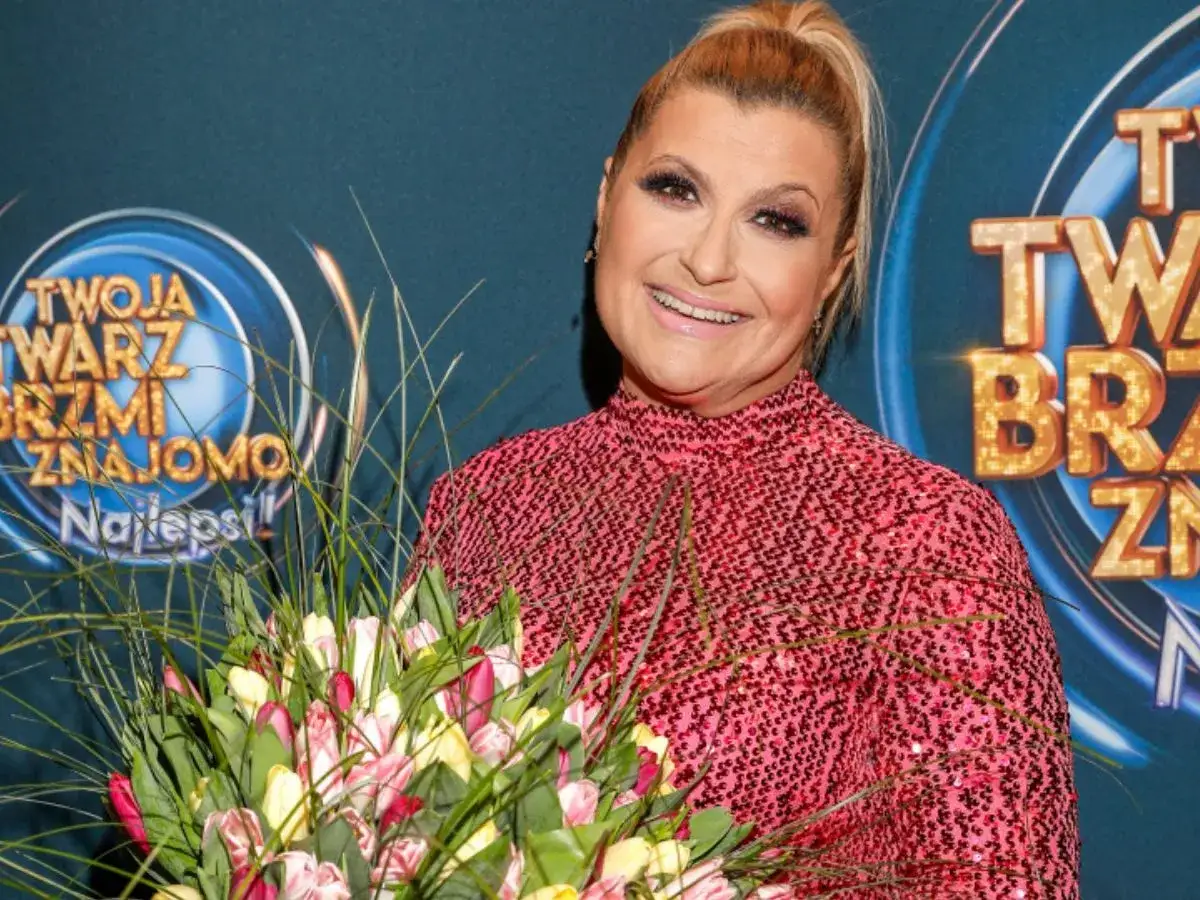 Małgorzata Szudarska Kuszewska z bukietem tulipanów na tle logo "Twoja twarz brzmi znajomo".