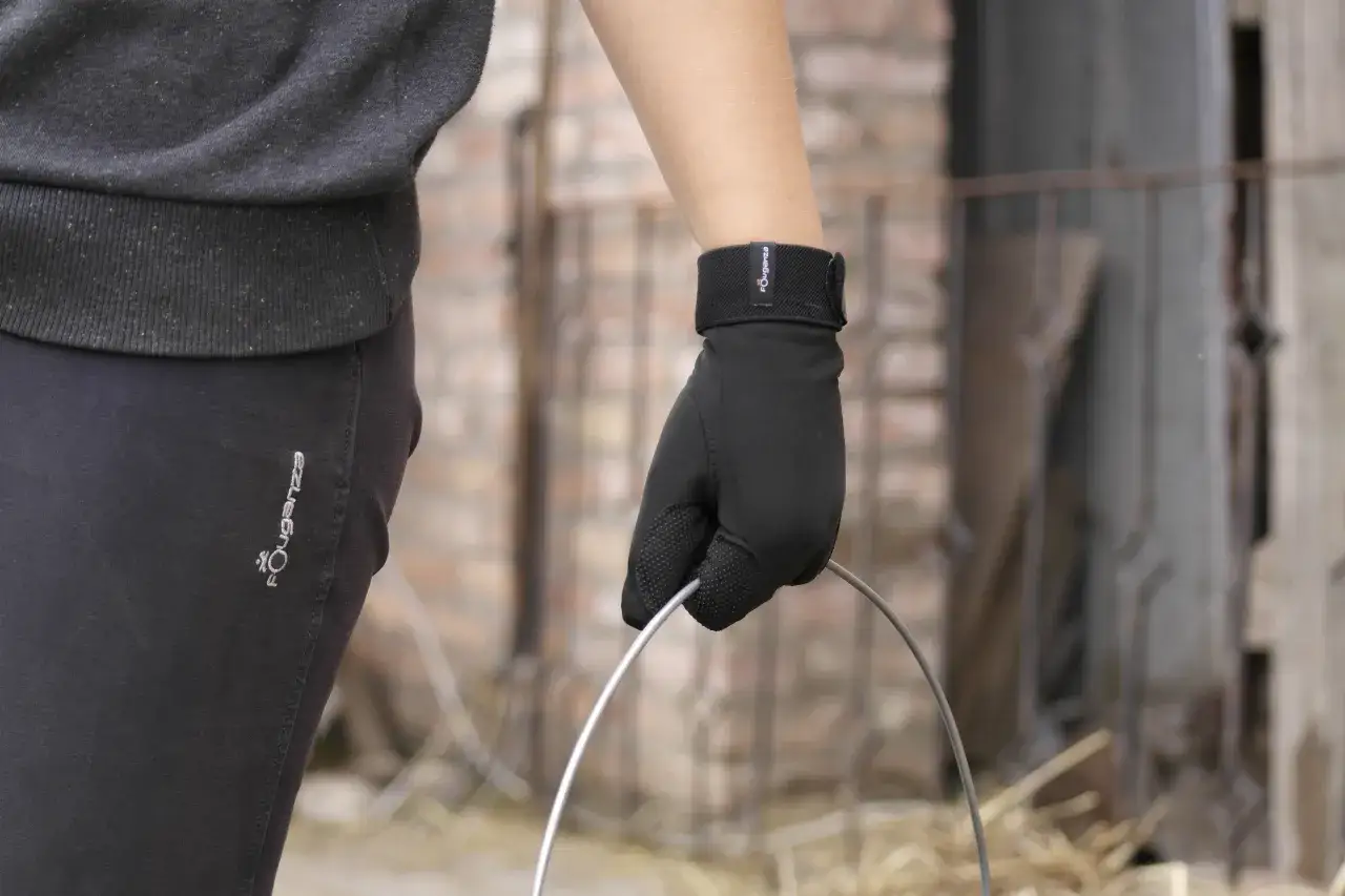 Dłoń w czarnej rękawiczce trzyma metalowy okrąg.