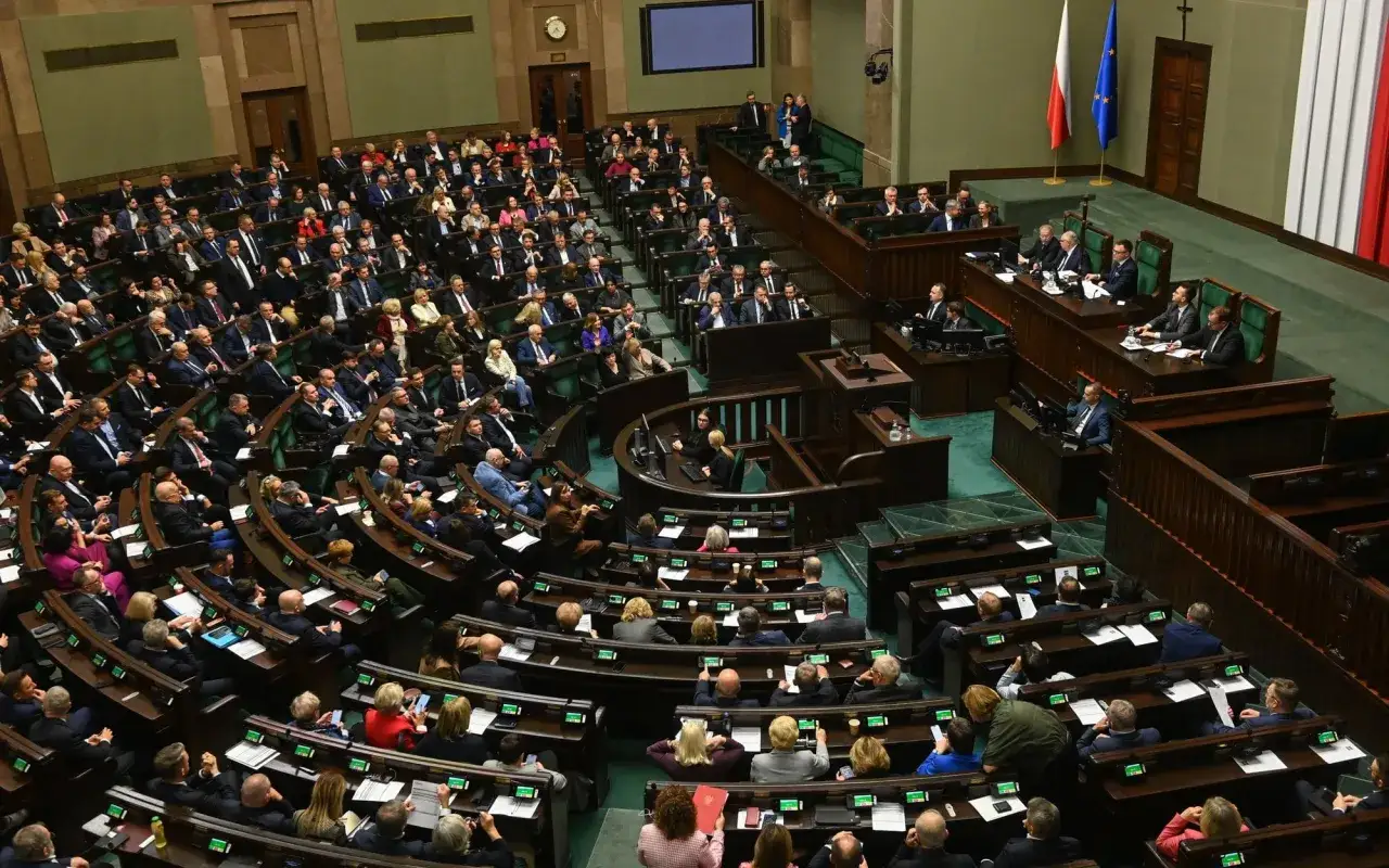 Posiedzenie Sejmu. Wiele osób siedzi w ławach, dyskutując o przyszłości kraju. Czy zaufanie do polityków jest uzasadnione?