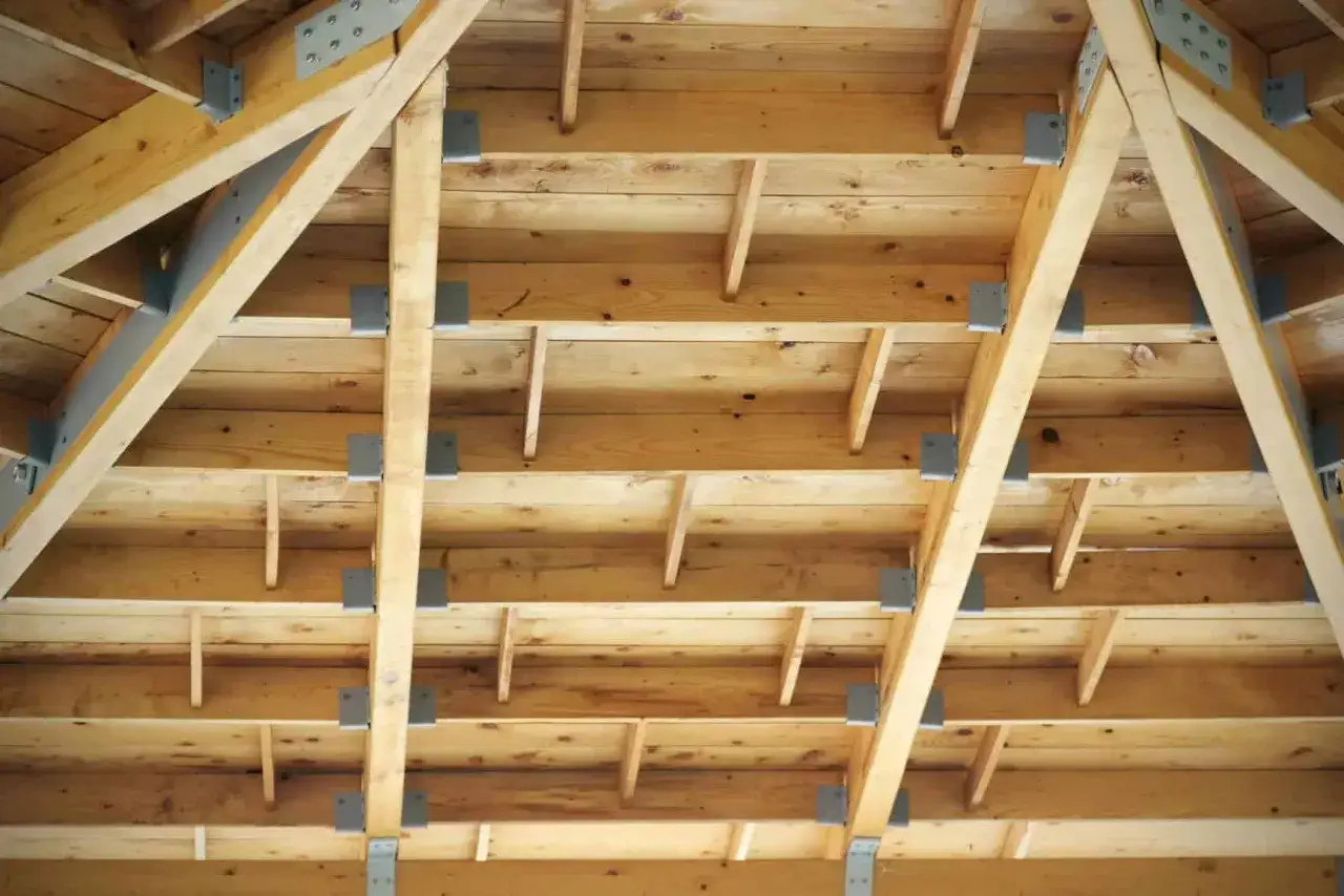 Drewniana konstrukcja stropu poddasza z metalowymi łącznikami.