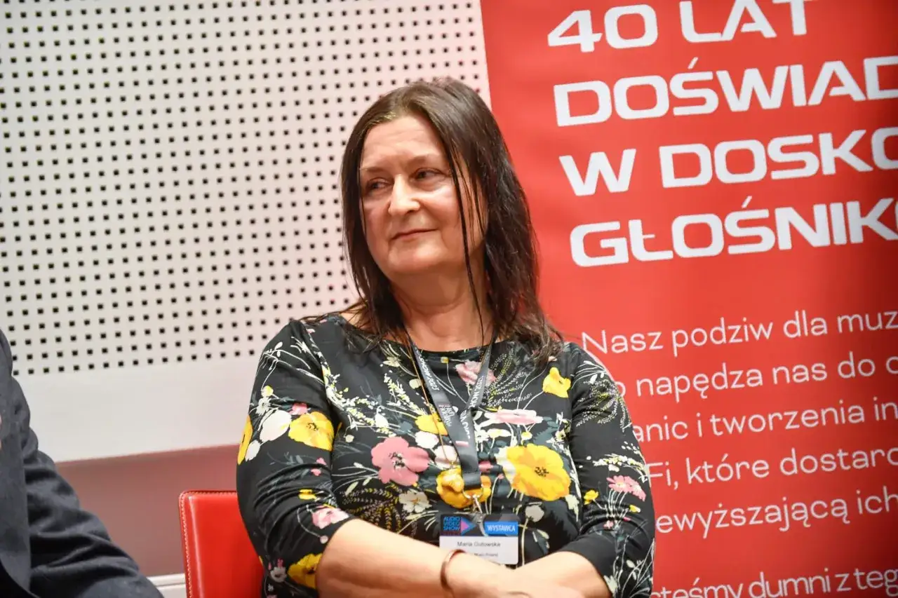 Maria Gutowska, córka Niemena, w kwiecistej sukience, z uśmiechem na twarzy, na tle napisu "40 lat doświadczenia w doskonałym brzmieniu".