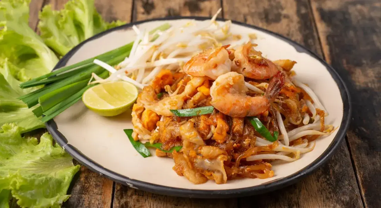 Pad Thai z krewetkami, kiełkami i limonką. Pyszne tajskie przepisy na talerzu.