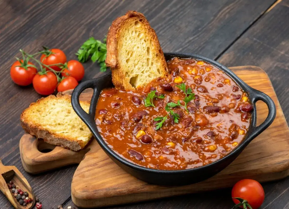 Pyszne chili con carne z fasolą i kukurydzą, idealne jako co na obiad na kilka dni. Podane z chrupiącym pieczywem i pomidorkami.