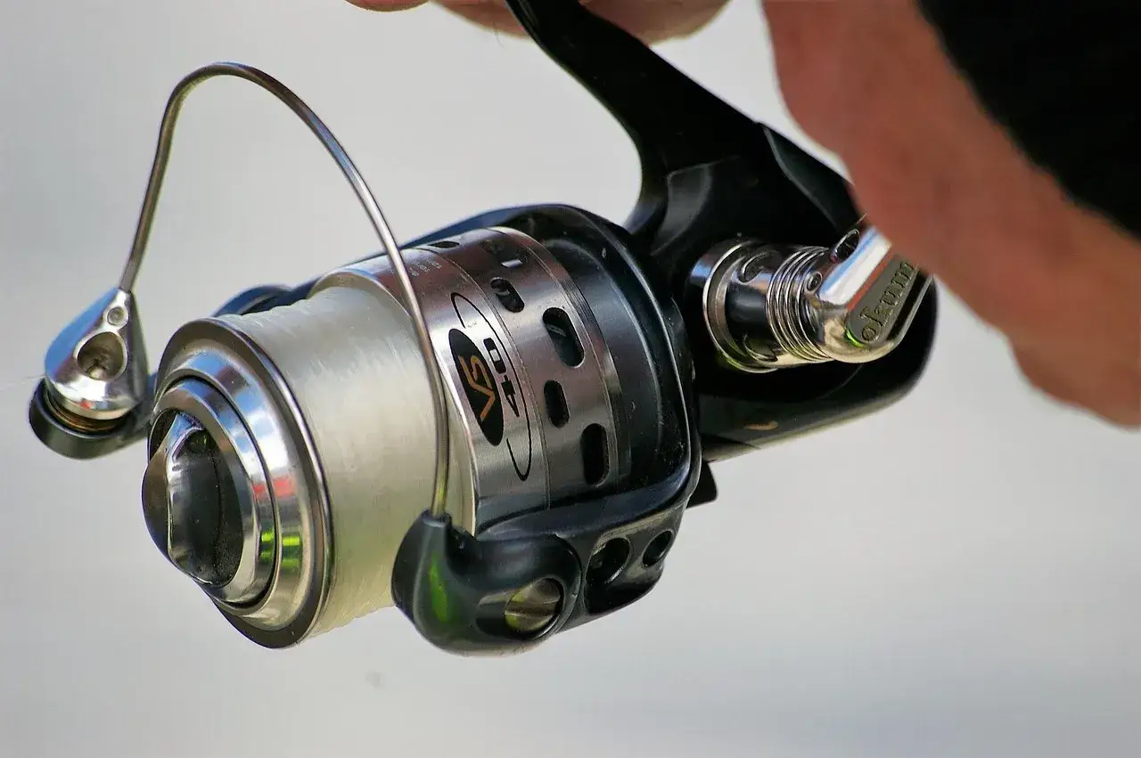 Kołowrotek spinningowy z nawiniętą żyłką, gotowy do akcji. Poznaj, jak zrobić spinning i łowić ryby!