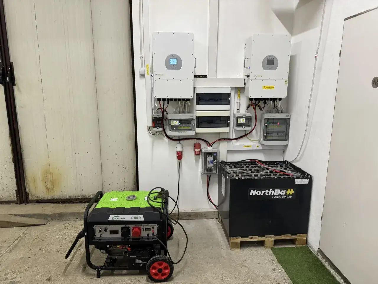 Instalacja fotowoltaiczna z falownikami, akumulatorami i agregatem prądotwórczym. System zapewnia niezawodne zasilanie.